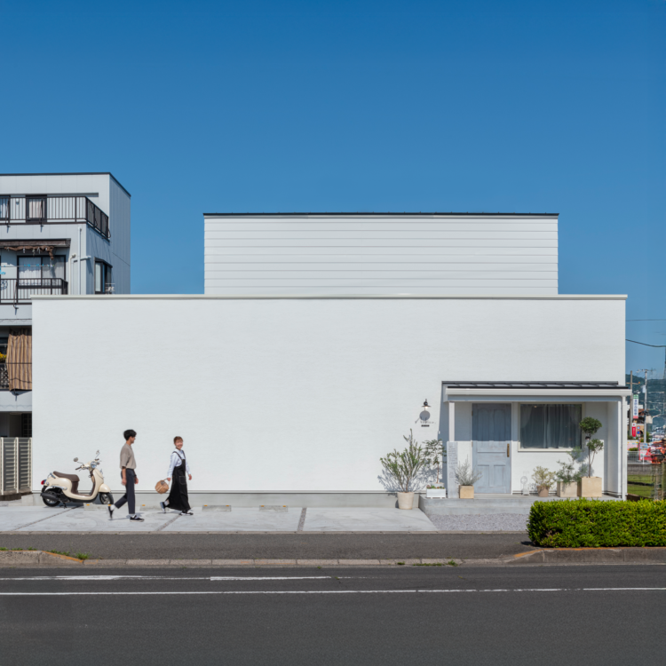友人をもてなす横長の白い家