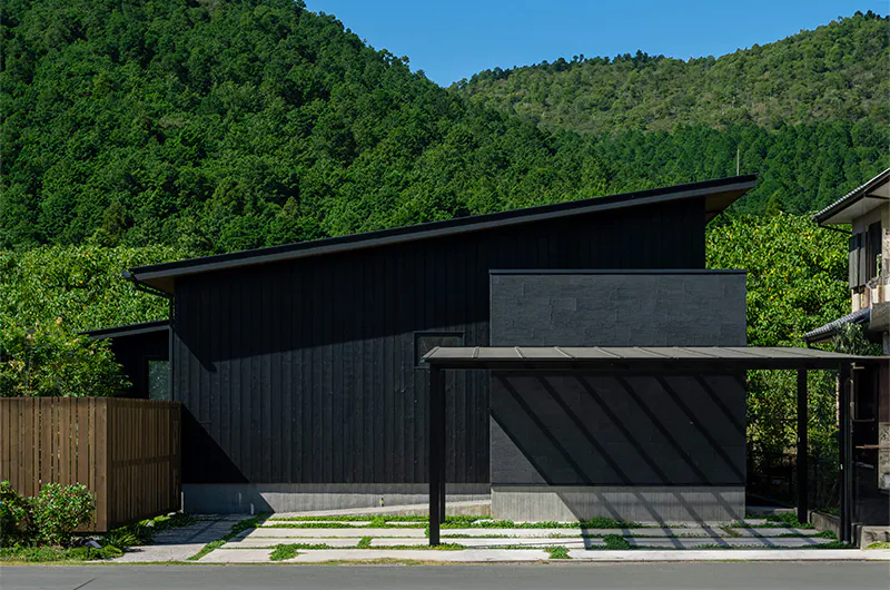 庭を囲む焼杉の片流れ屋根の平屋の外観