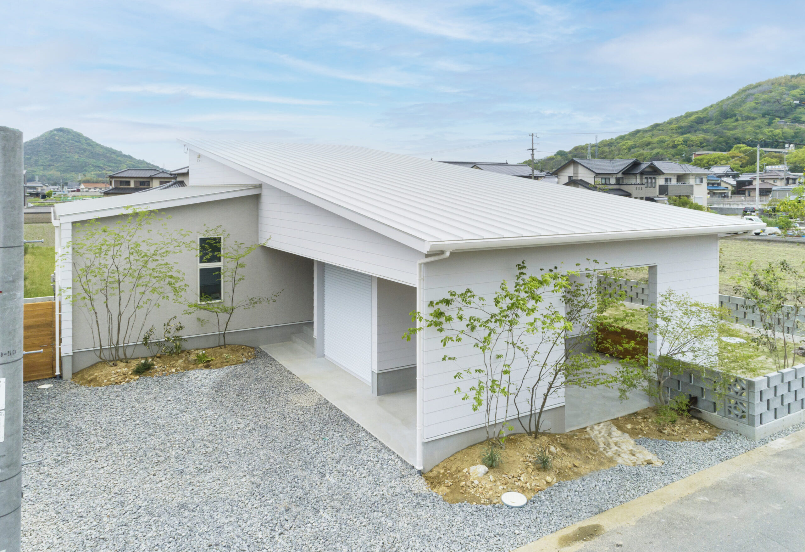 ホワイト基調のブロック石やガレージがおしゃれな平屋外構の外観