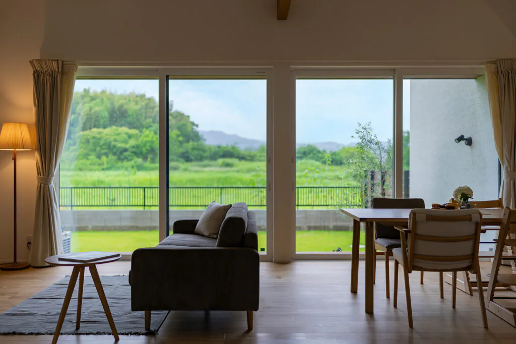 円窓から紅葉を眺める和モダンな平屋の内観